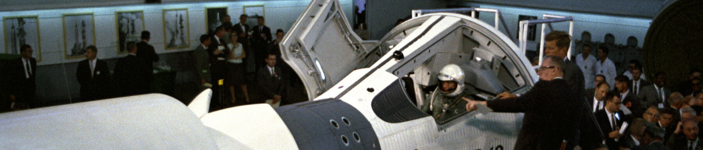 President Kennedy looks at a space capsule